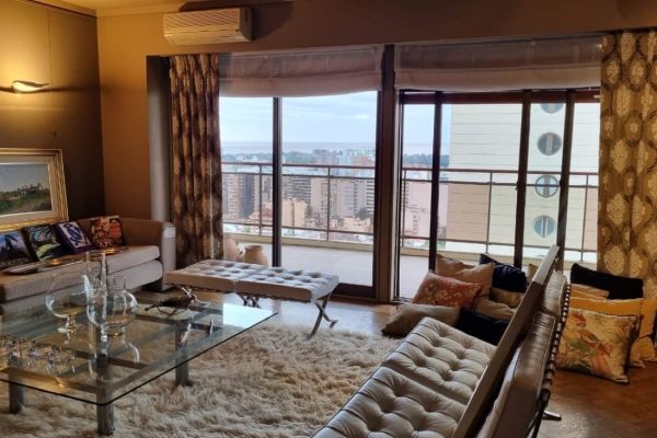 Sillón en L de diseño tapizado en pana; 2 sillones diseño Barcelona con apoya pies; mesas auxiliares: de diseño, de Interior Forma, para TV; esquinero en raíz de nogal; comedor diseño: mesa en madera con 8 sillas; mueble con cajón y tapa mármol, otros; cama con respaldo en cuero, banqueta pie de cama, mesas de luz-Adornos, cristalería, copas; escultura 