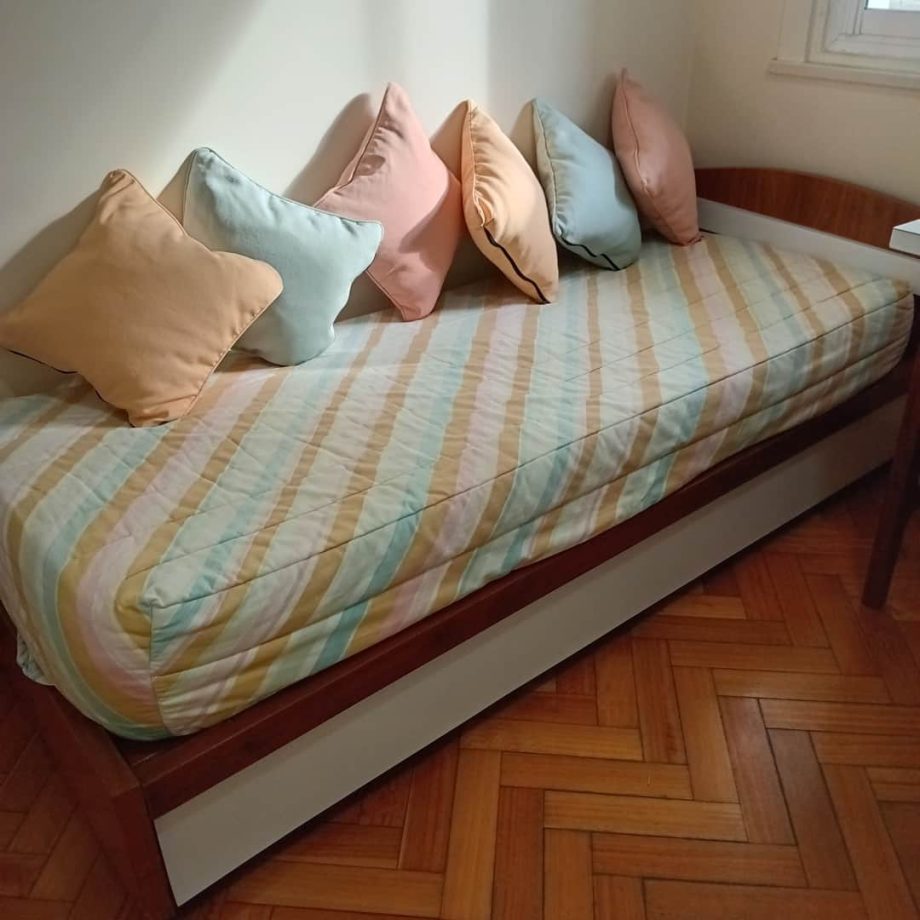 Cama con almohadones y cubre colchón