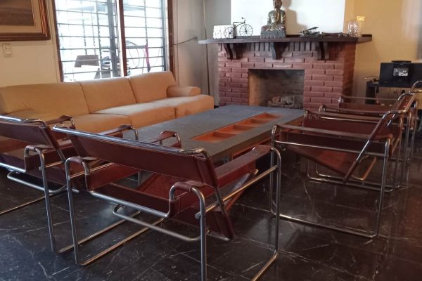 Sofá 3 cuerpos; par butacas; 4 sillones diseño Wassily; mecedora Thonet; mesas auxiliares: tapa rectangular metal y vítrea, alta, carro en metal 2 planos, carro bar con bandeja desmontable; consola diseño en madera; cajonera baja; biblioteca 3 módulos con rieles; escritorio Dash y otro; mueble auxiliar con cajones; mueble zapatero 3 puertas-Adornos y vajilla: juego para te porcelana Verbano, vajilla con te y café Noritake; cristalería, copas Baccarat modelo Dom Perignon...