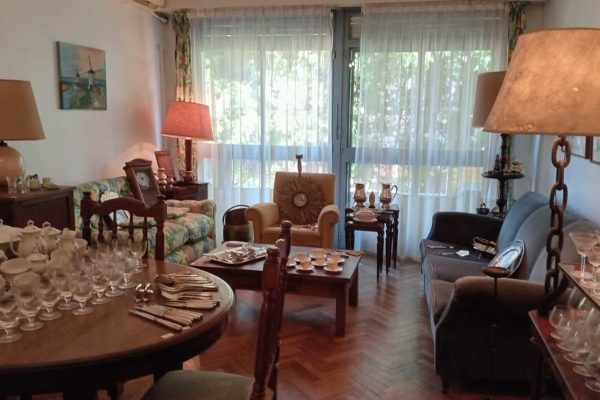 Sofá 3 cuerpos tapizado en pana verde; sofá 2 cuerpos tapizado floreado con respaldo capitoné; sillón 1 cuerpo en color maíz; sillón 1 cuerpo formato herradura; silla respaldo labrado asiento tapizado; silla hamaca; silla matera; sillón hamaca; mesas auxiliares: tapa rectangular, estilo Adams con alas y cajones, mayordomo estilo Francés con herrajes y aplicaciones bronce, nido estilo Inglés, con alas; mueble de guardado 2 puertas con alzada biblioteca, otro auxiliar 3 canastos...