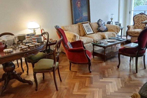 Sofá 3 cuerpo tapizado en género labrado color dorado; diván estilo Francés esterillado verde con 2 colchones; par silloncitos estilo Inglés tapizado pana bordó; par sillones 1 cuerpo estilo Colonial Inglés con ruedas; par sillones 1 cuerpo estilo Inglés tapizado hojas; sillón 1 cuerpo estilo Colonial Inglés tapizado en terciopelo colorado; par sillones tapizados en lino color cemento con almohadones y banqueta ídem; mesas auxiliares: par cuadradas doble plano, nido, rectangular doble plano 2 cajones...