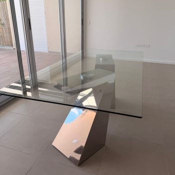 Mesa de diseño con tapa vitrea y patas cromadas