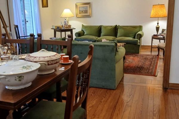 Sofá 3 cuerpos tapizado en pana verde; sillón 1 cuerpo estilo lnglés; par sillones 1 cuerpo tapizado pana verde; par sillas con respaldo esterillado asiento en pana natural; par sillas estilo Ingles; baqueta con funda; sillon descanso; msesa auxiliares: vintage, carro 3 planos con ruedas y bandeja desmontable, frente sofá pequeña; mueble cubertero y otro de mesa; consola en roble doble pedestal, otra 2 cajones doble pedestal; comedor roble con laterales extensibles, 8 sillas asiento tapizado pana verde; bibliotecas 5 estantes...
